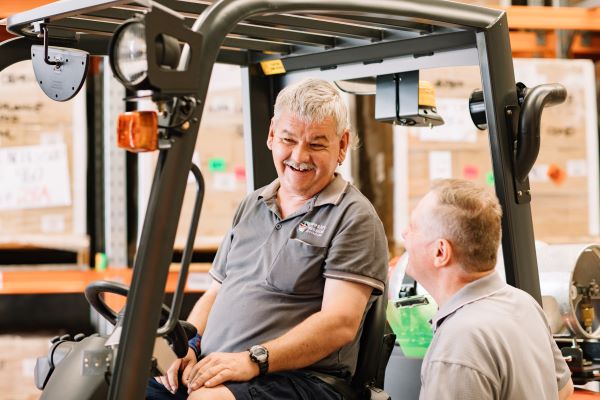 Worker in forklift talking to another worker