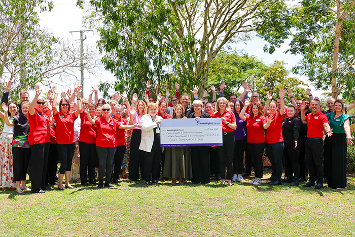 Group holding a corporate donation check at WMQ