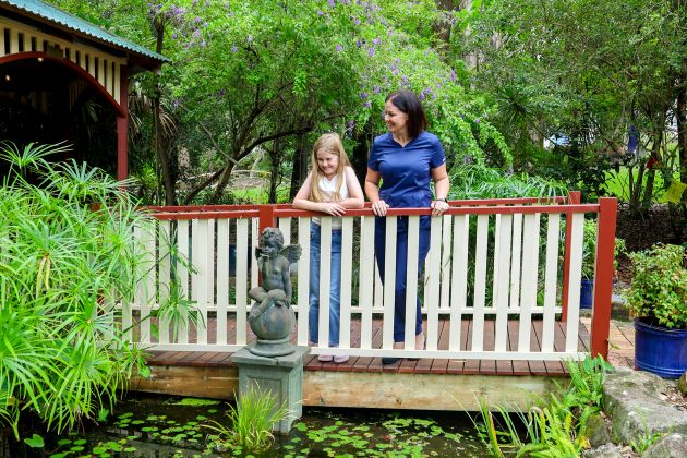 A woman and child smiling by a bridge