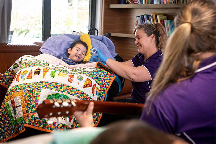 Child in bed with a nurse at Hummingbird House
