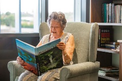Resident reading in armchair Dovetree