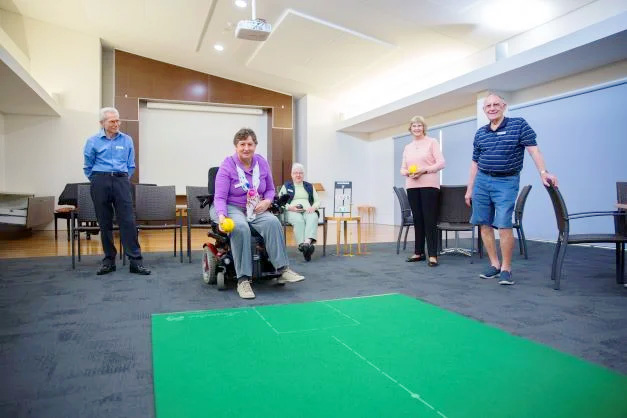 Retirees play indoor bowls in  our residential aged care community in Brisbane
