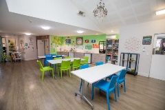 Large dining room with tables and blue and green chairs