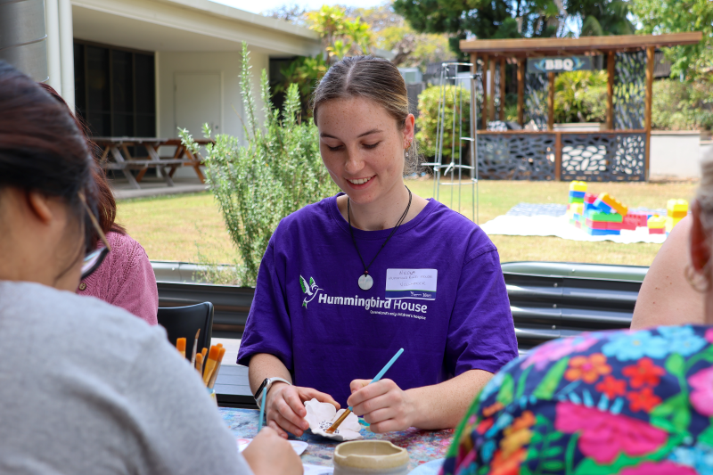 Hummingbird House staff painting a ceramic flower